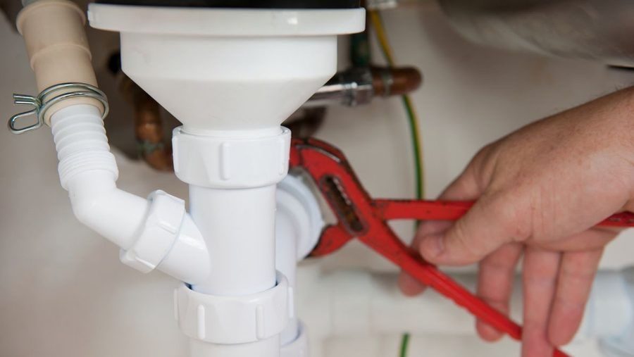 Plumber conducting drain cleaning service.