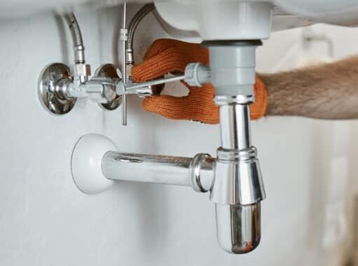 plumber inspecting sink pipes