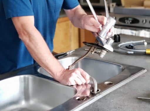 A plumber in Delaware clearing faucets for rooter cleaning | Delaware Drain Services | Call Harris Now