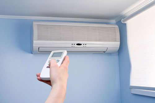 Homeowner using remote to control ductless mini-split
