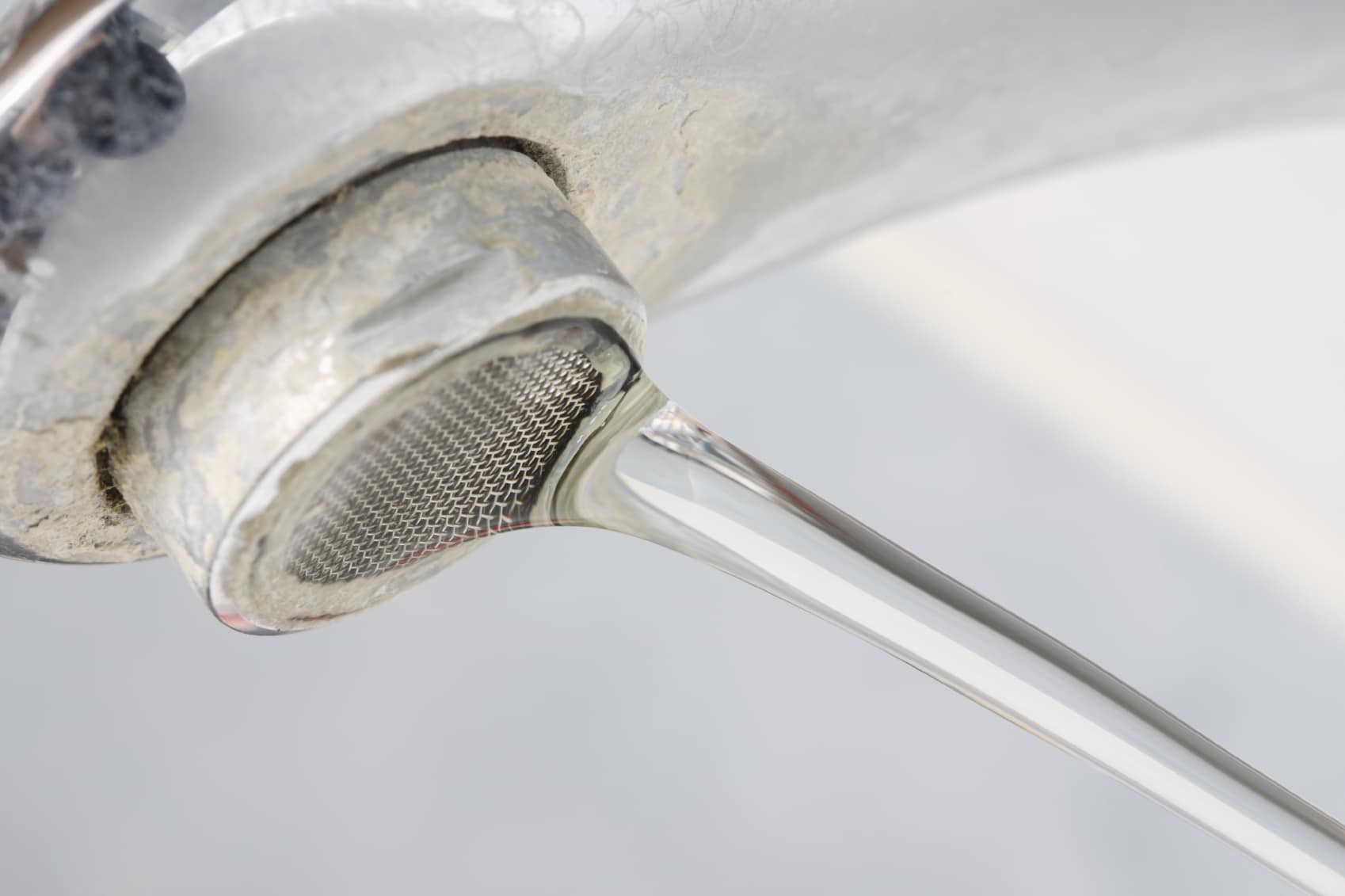 hard water stains on sink faucet with water running