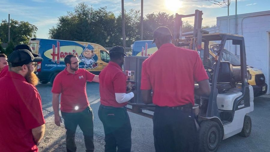 Harris techs unloading HVAC unit during emergency heating service.