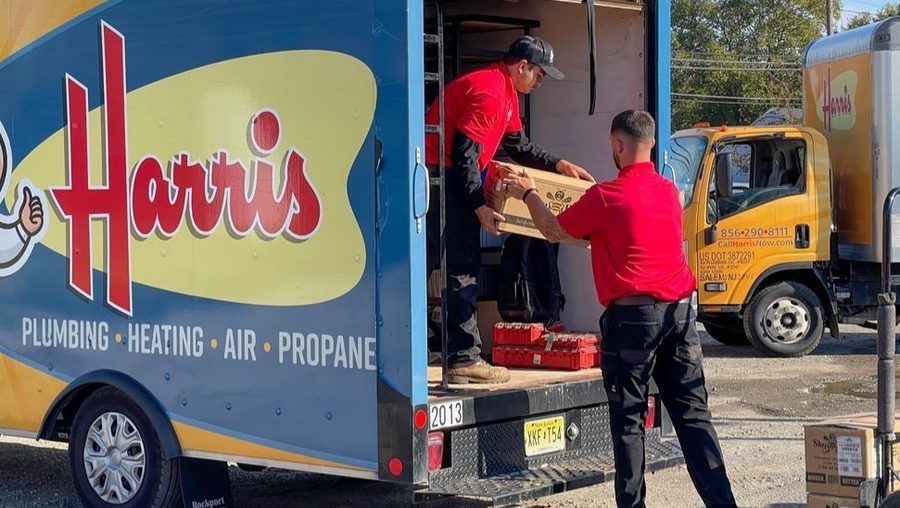 Harris plumbers unloading heating equipment.