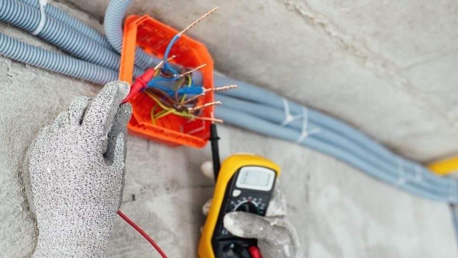 Electrician testing wiring during an electrical repair.
